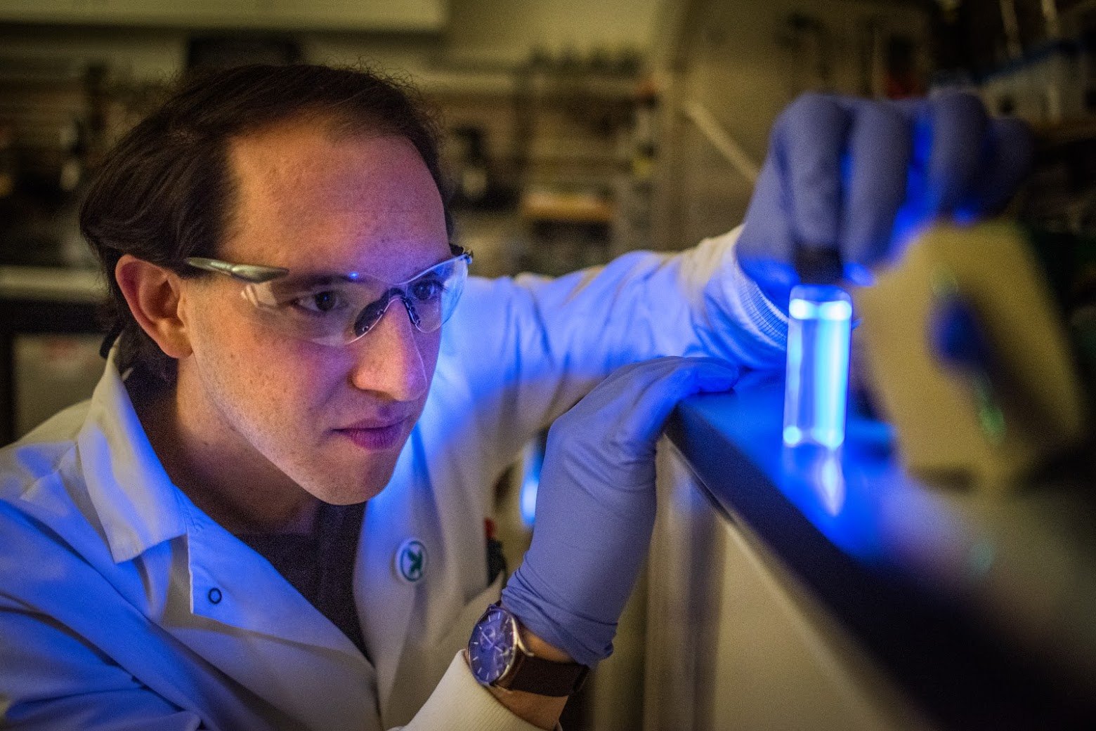 Cofounder David Romney looking at a vial containing a blue chemical